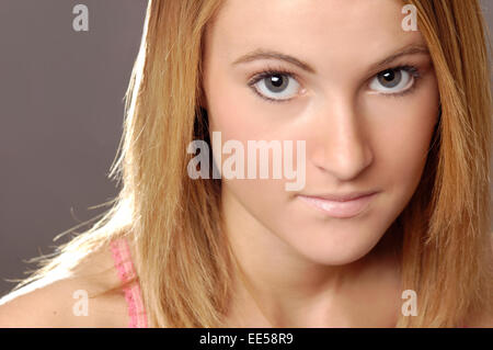 Questo stock foto mostra una giovane donna con la pelle chiara e naturale alla ricerca di make-up. Ella è rendere il contatto visivo con il visualizzatore Foto Stock