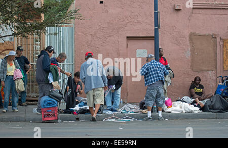 Persone senza dimora il prelievo attraverso donazioni di abbigliamento posto sulla strada dal gruppo di Chiesa, East Village, San Diego, California USA Foto Stock