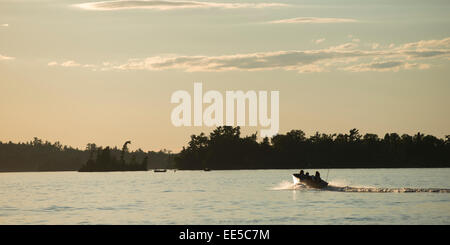 Barca a muovere in un lago, lago dei boschi, Ontario, Canada Foto Stock