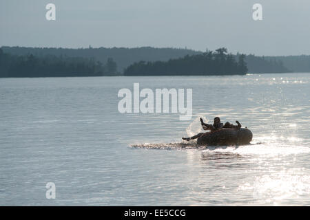 Turisti che si godono sulla zattera gonfiabile in un lago, il lago dei boschi, Ontario, Canada Foto Stock