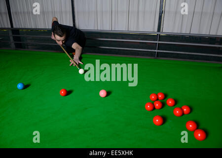 Giovane uomo giocare biliardo Foto Stock