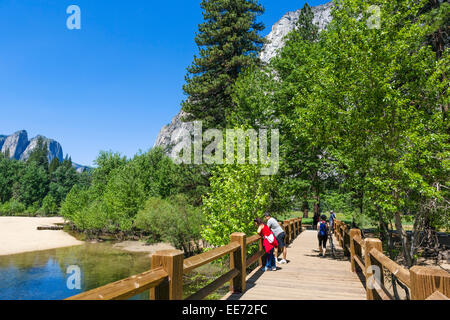 Swinging ponte attraverso il Fiume Merced, Yosemite Valley, del Parco Nazionale Yosemite, Sierra Nevada, a nord della California, Stati Uniti d'America Foto Stock