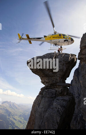 Un elicottero è in bilico su una roccia spettacolare. In tal modo di un ponticello di base è di uscire dalla cabina. Egli farà un salto dalla rupe Foto Stock