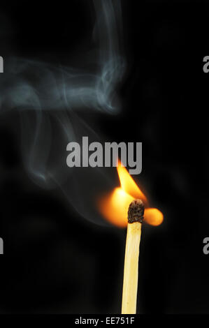 Confronto di accensione di fiamme e fumo contro uno sfondo nero Foto Stock