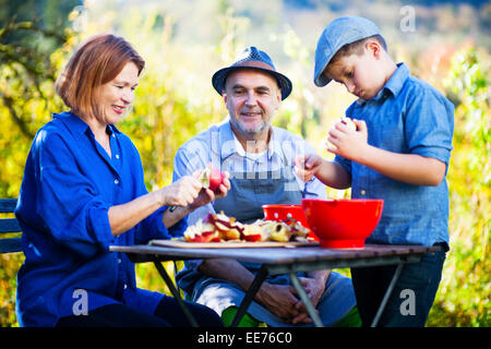 Multi-generazione famiglia sbucciare le mele, Monaco di Baviera, Germania Foto Stock