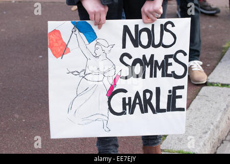 Una giovane donna con uno slogan "Siamo Charlie' durante la raccolta di "Je Suis Charlie' veglia a Laval città. Foto Stock