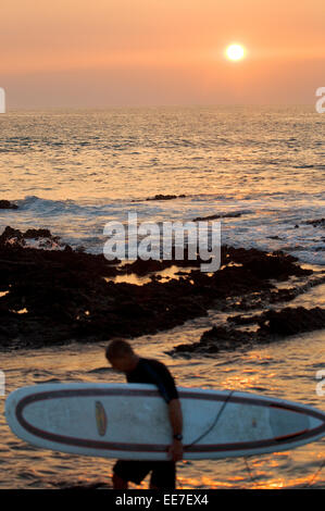 Surfer al tramonto sulla spiaggia di Waikoloa. Big Island. Stati Uniti d'America. Surfisti in corallo e lava Anaeho fianco'omalu Bay nelle Hawaii. Waik Foto Stock