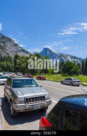 Auto parcheggiate su Northside Dr nr Yosemite Falls con mezza cupola in distanza, Yosemite Valley, Yosemite National Park, CA, Stati Uniti d'America Foto Stock