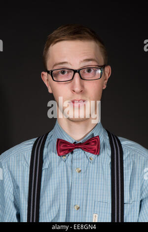 Uomo in un rosso bow tie plaid shirt cerca su occhiali su uno sfondo nero Foto Stock