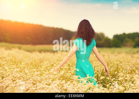 Felice giovane ragazza camminare sul prato di fiori Foto Stock