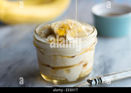 Erba alimentato lo yogurt greco parfait con miele e banane Foto Stock