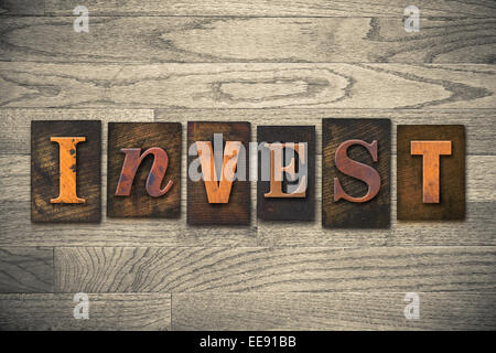 La parola "INVEST" scritto in legno tipo di stampa in rilievo. Foto Stock