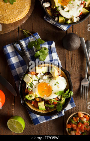 In casa Heuvos Rancheros con Avocado e coriandolo Foto Stock