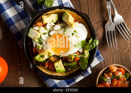 In casa Heuvos Rancheros con Avocado e coriandolo Foto Stock