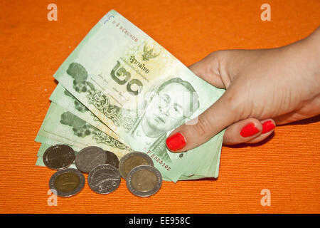 Thai baht - le banconote e le monete in euro nella donna la mano Foto Stock