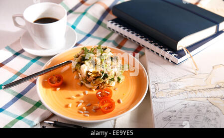 Insalata russa per la colazione su un panno a scacchi e taccuini Foto Stock