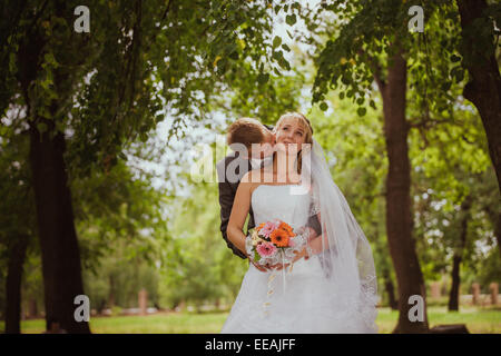 Sposa e lo sposo in un parco kissing.giovane sposi sposa e lo sposo a un matrimonio in natura verde della foresta sono kissing photo portrai Foto Stock