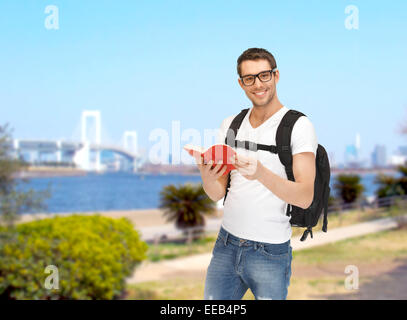 Studente di viaggio con zaino e prenota Foto Stock