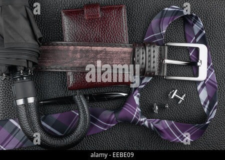 Legare la cinghia, portafogli, gemelli, penna e ombrello giacente sulla pelle, può essere utilizzato come sfondo Foto Stock