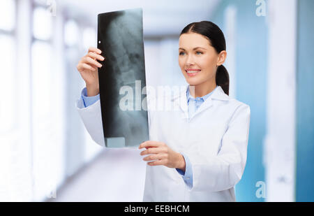 Donna sorridente medico guardando a raggi x Foto Stock