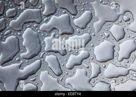 Effetto dell'acqua sulla parte superiore di un tavolo in acciaio inox. Foto Stock