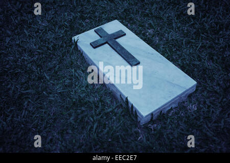 Immagine in bianco e nero di una croce su una lastra di marmo, segnando un grave in questo cimitero in Singapore Foto Stock