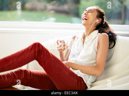 Ragazza godendo ascoltando la musica che indossano le cuffie Foto Stock