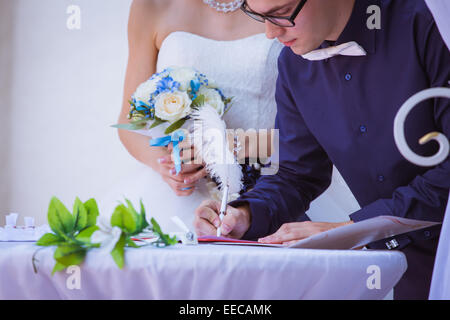 Lo sposo firma certificato di matrimonio in posizione di parcheggio Foto Stock