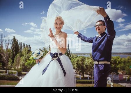 Coppia di novelli sposi ballare accanto a un lago Foto Stock