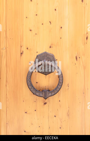 Un anello di metallo come un respingente porta su una porta di legno Foto Stock