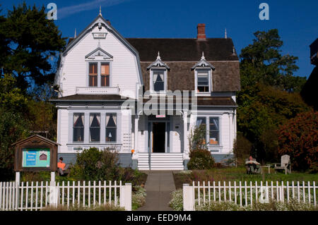 Elegante costiera californiana architettura mare in legno struttura anteriore con un blu cielo soleggiato e pallido color pastello edificio Mendocino Foto Stock