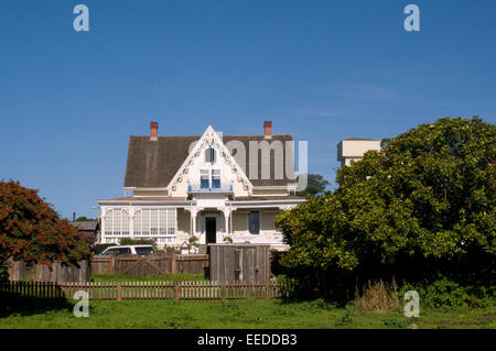 Elegante costiera californiana architettura mare in legno struttura anteriore con un blu cielo soleggiato e pallido color pastello edificio Mendocino Foto Stock