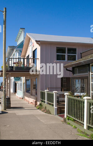 Elegante costiera californiana architettura in legno fronte mare di strutture con un blu cielo soleggiato e pallido edifici color pastello Mendocino Foto Stock