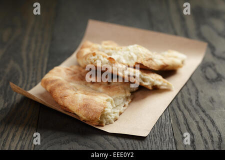 Pane appena sfornato georgian pane pita su carta, legno tavolo in legno di quercia Foto Stock