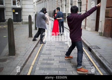 Asian fotografo fotografare una coppia cinese per le loro foto del matrimonio. Londra, Regno Unito. Questa è una visione comune come coppie provenienti da Asia hanno le loro fotografie fatto come prima del loro effettivo giorno di nozze indossando il loro abito e tuta. Foto Stock