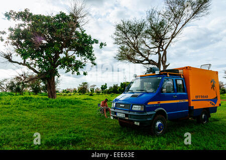 Uomo con 4x4 spedizione carrello campeggio nel bush, Senegal. Foto Stock