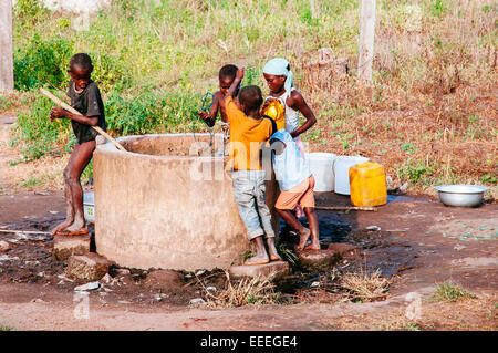 Bambini raccolta di acqua da un pozzo, Ghana Foto Stock