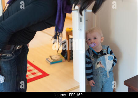 Freiburg, Germania, piccolo ragazzo nascosto dietro una porta Foto Stock