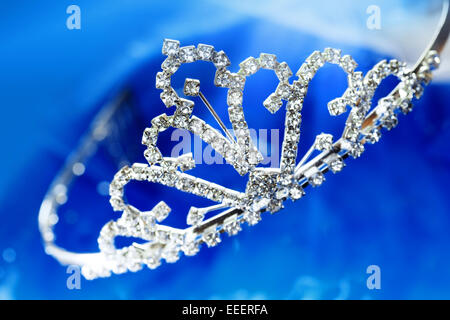 Close-up di foto il diadema di argento con diamanti su uno sfondo blu con bokeh di fondo Foto Stock