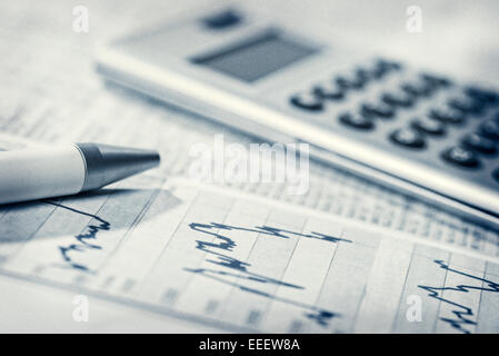 Diagrammi con i prezzi di mercato, tasso di cambio tavoli, penna e calcolatrice.