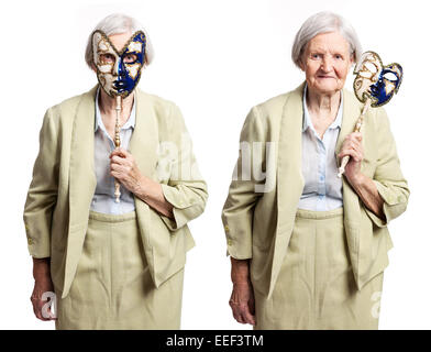 Donna anziana con maschera di Carnevale in piedi su bianco Foto Stock