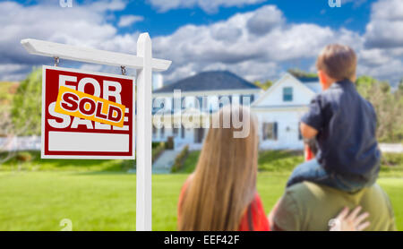 Curioso rivolto verso la famiglia venduto per la vendita immobiliare di segno e bella casa di nuova costruzione. Foto Stock