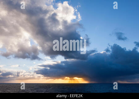 Il sun streaming attraverso le nuvole in mare intorno alle isole Canarie. Foto Stock