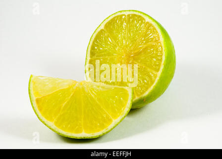 Limes, limoni con fette. Limes, limoni con fette isolati su sfondo bianco. Foto Stock