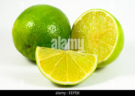 Limes, limoni con fette. Limes, limoni con fette isolati su sfondo bianco. Foto Stock