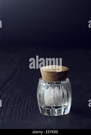 Close up di un rustico shaker sale su tavoli in legno nero Foto Stock