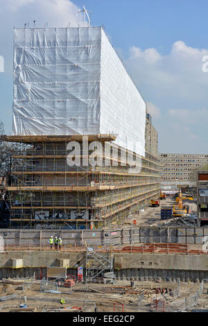 Alloggi sociali estate rivestite di fogli di plastica &ponteggi per demolizione edificio nuovo lavoro iniziato su area svuotata Heygate Estate London REGNO UNITO Foto Stock