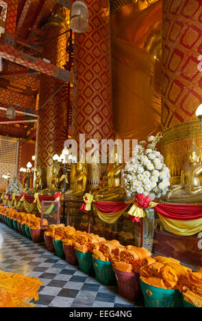 TH00294-00...THAILANDIA - Sciarpe da cerimonie precedenti memorizzati dietro la statua di Buddha a Wat Phanan Choeng. Foto Stock