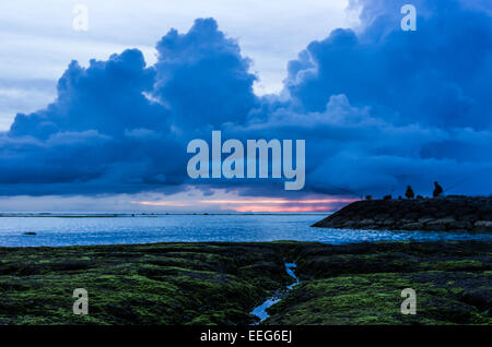 I pescatori pausa per guardare il tramonto a Sunabe Beach a Okinawa, Giappone. Foto Stock