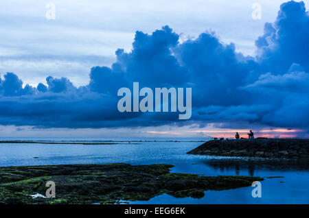 I pescatori pausa per guardare il tramonto a Sunabe Beach a Okinawa, Giappone. Foto Stock